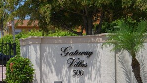 Schild für Gateway Villas, Hausnummer 500, mit Ziegelweg und Grünpflanzen im Vordergrund.