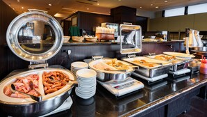 Una mesa de buffet con diversos alimentos y utensilios para servir.