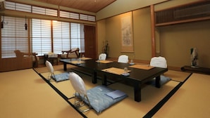 A traditional Japanese meeting room with tatami flooring, a long table, and shoji screens. - Kogushiya (Shimonoseki)