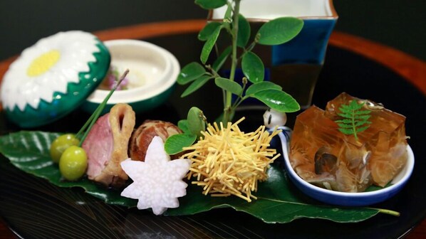 A traditional Japanese meal with various dishes including sushi, sashimi, and pickled vegetables.