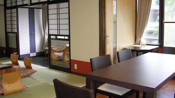 Una habitación tradicional japonesa con suelo de tatami, una mesa baja y puertas correderas.
