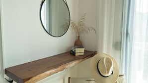 Een houten plank met een spiegel, een plant en een hoed.