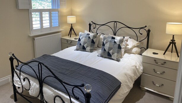 A bedroom with a bed, bedside tables, a window, and a radiator. -  Holiday rental in Rye, sleeps up to 6 with private gated driveway (Rye)