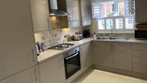 A modern kitchen with a gas stove, oven, and stainless steel appliances. -  Holiday rental in Rye, sleeps up to 6 with private gated driveway (Rye)