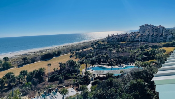 A coastal resort with a swimming pool, beachfront views, and a large building complex. - Omni Resort - Gorgeous Top Floor Penthouse with Oceanfront Views - Shipwatch! (Fernandina Beach)