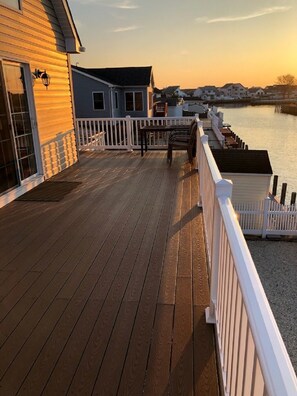 A wooden deck with a white railing, overlooking a body of water with houses in the background. - New waterfront Beach Haven West 3 Bedroom & 3 Baths Vacation Rental  (Beach Haven West)