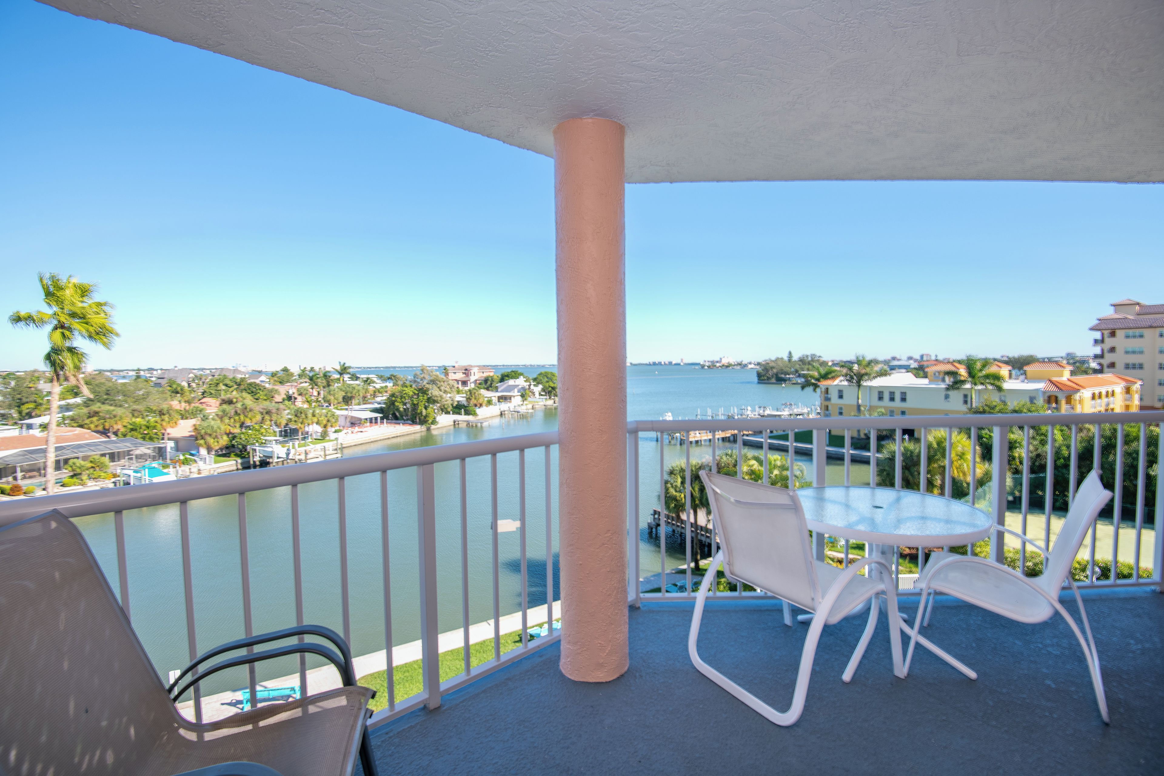 A balcony with a view of a marina and buildings across the water.