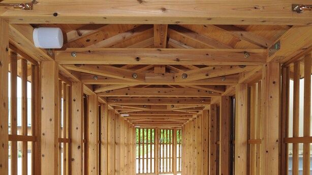 Un pasillo de madera con techo inclinado y ventanas grandes.