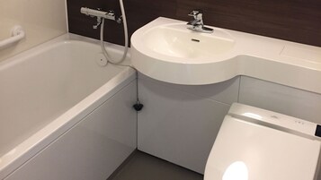 Un baño con bañera, lavabo e inodoro.