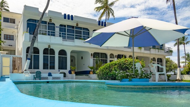 A two-story building with a pool, white exterior, and blue accents. - Suites La Audiencia (Manzanillo)