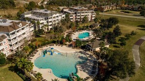 Ein Resort mit einem großen zentralen Pool, mehreren Gebäuden und einer gepflegten Parkanlage.
