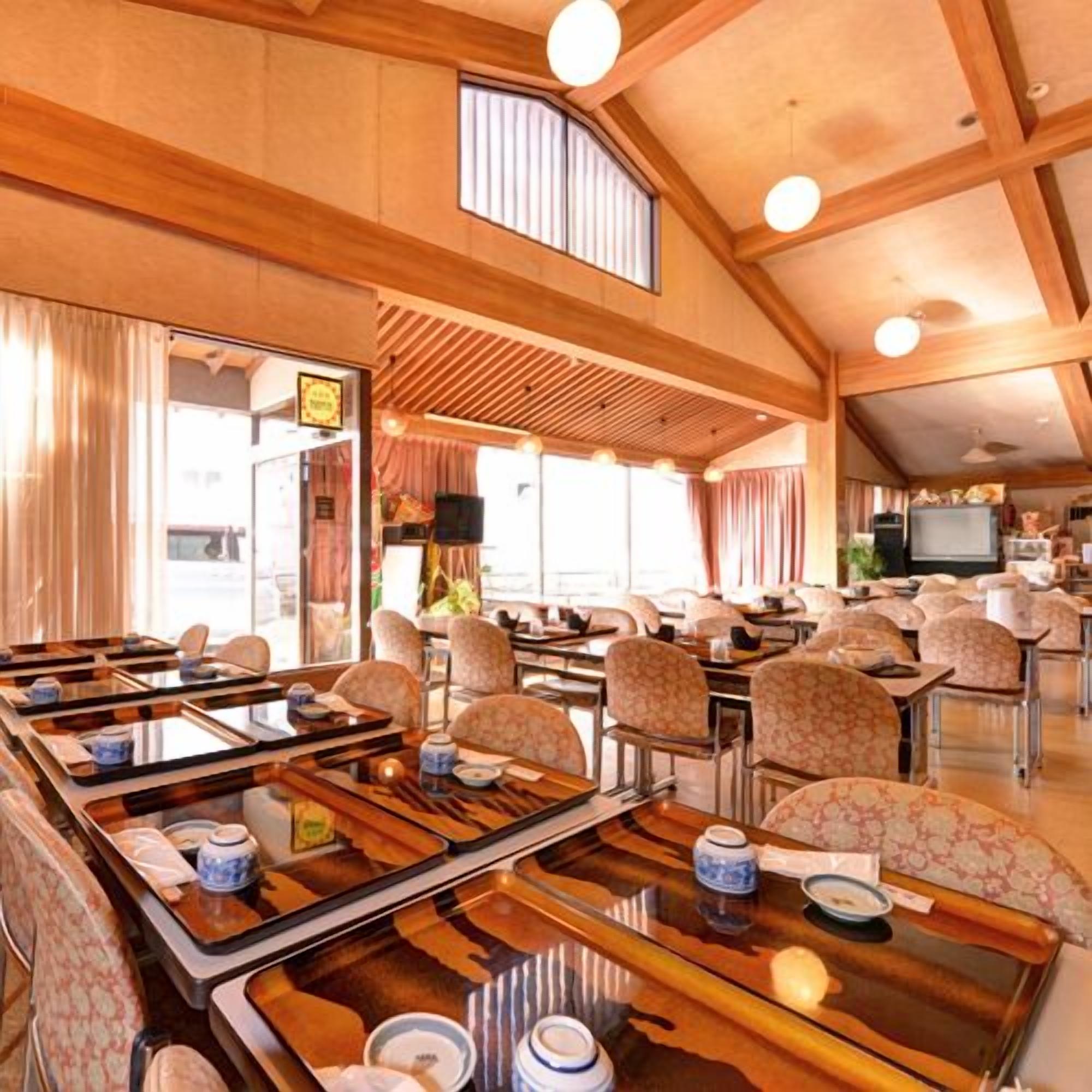 Un restaurant de style japonais traditionnel, avec des tatamis pour s’asseoir, des poutres en bois et un téléviseur discret au fond de la salle.