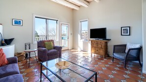 A spacious living room with a glass coffee table, two sofas, a television, and a wooden cabinet. - 432casavivahenco - Casa Viva (Santa Fe)