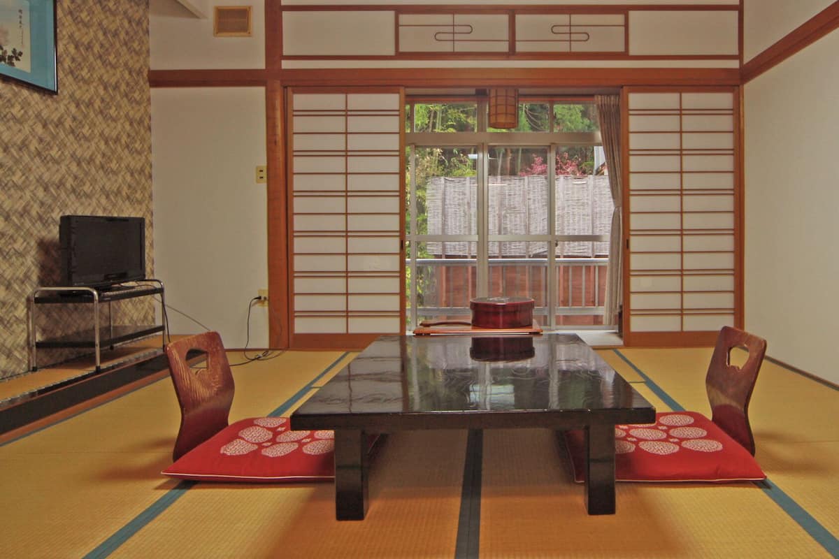 A traditional Japanese-style room with tatami flooring, a low table, and shoji screens.