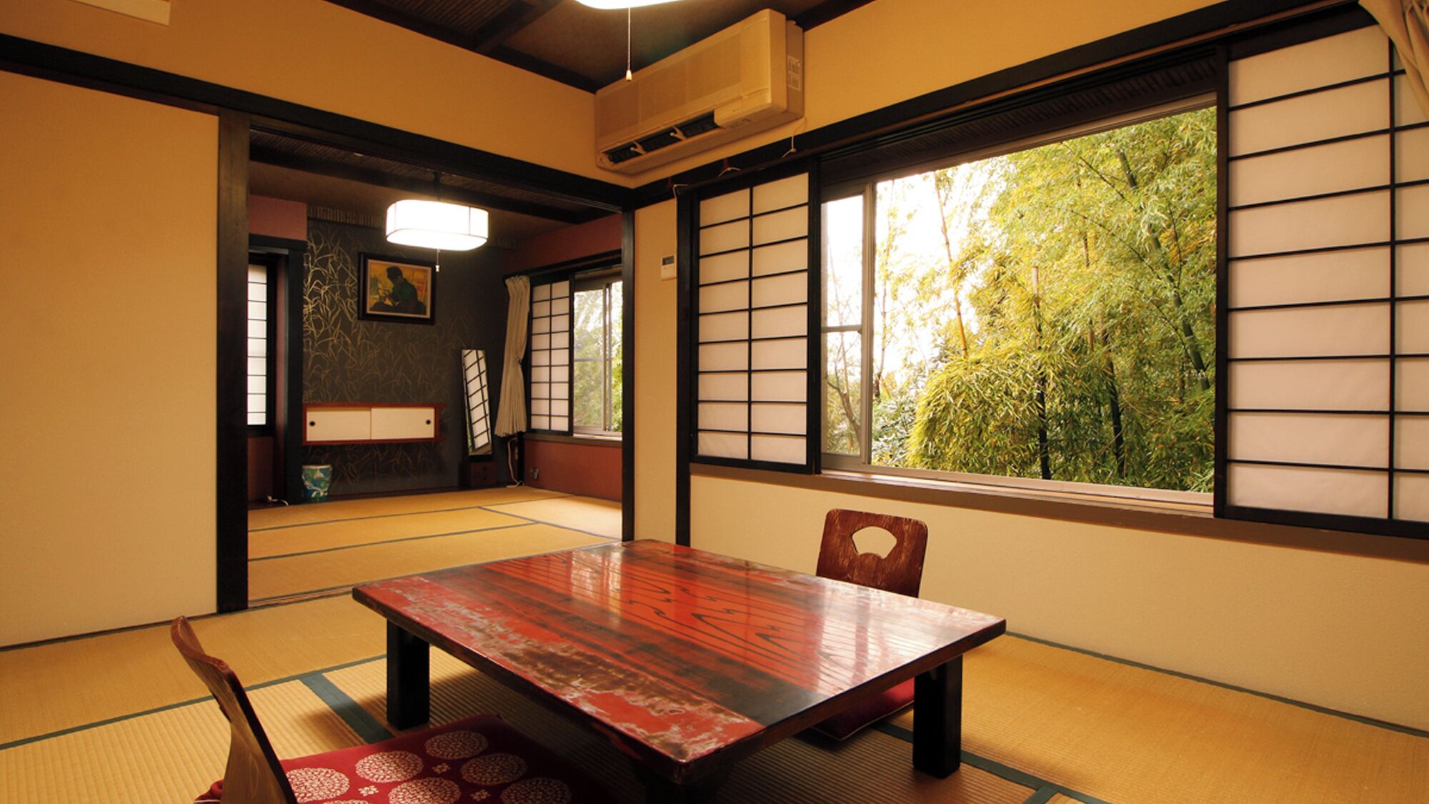 Una habitación tradicional japonesa con suelo de tatami, una mesa de madera y paneles shoji.