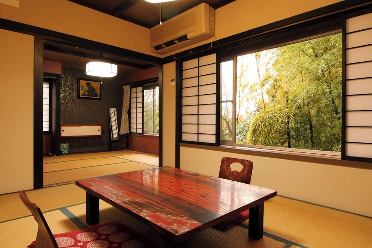 A traditional Japanese room with tatami flooring, a wooden table, and shoji screens.