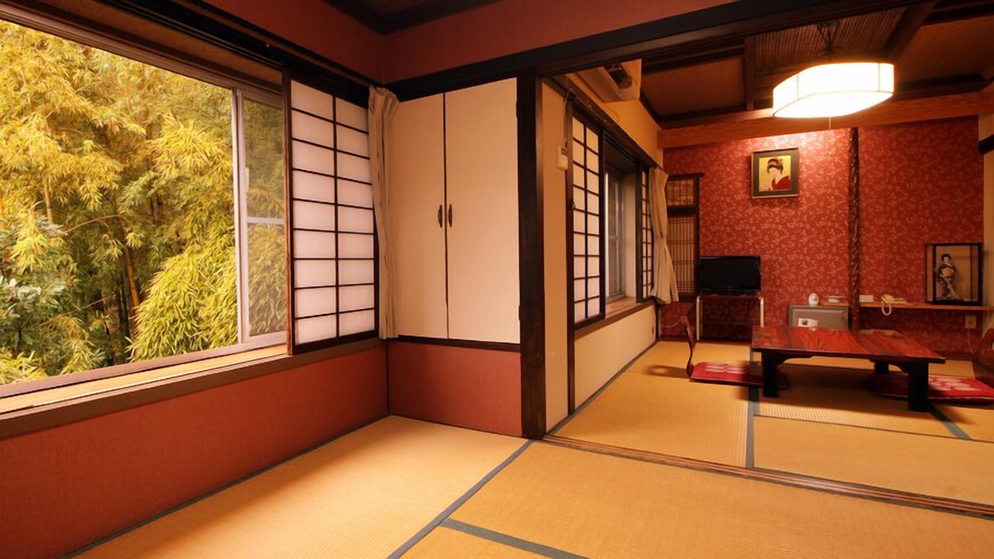 Une pièce de style japonais traditionnel, avec un sol recouvert de tatamis, des portes coulissantes et une vue sur les arbres.