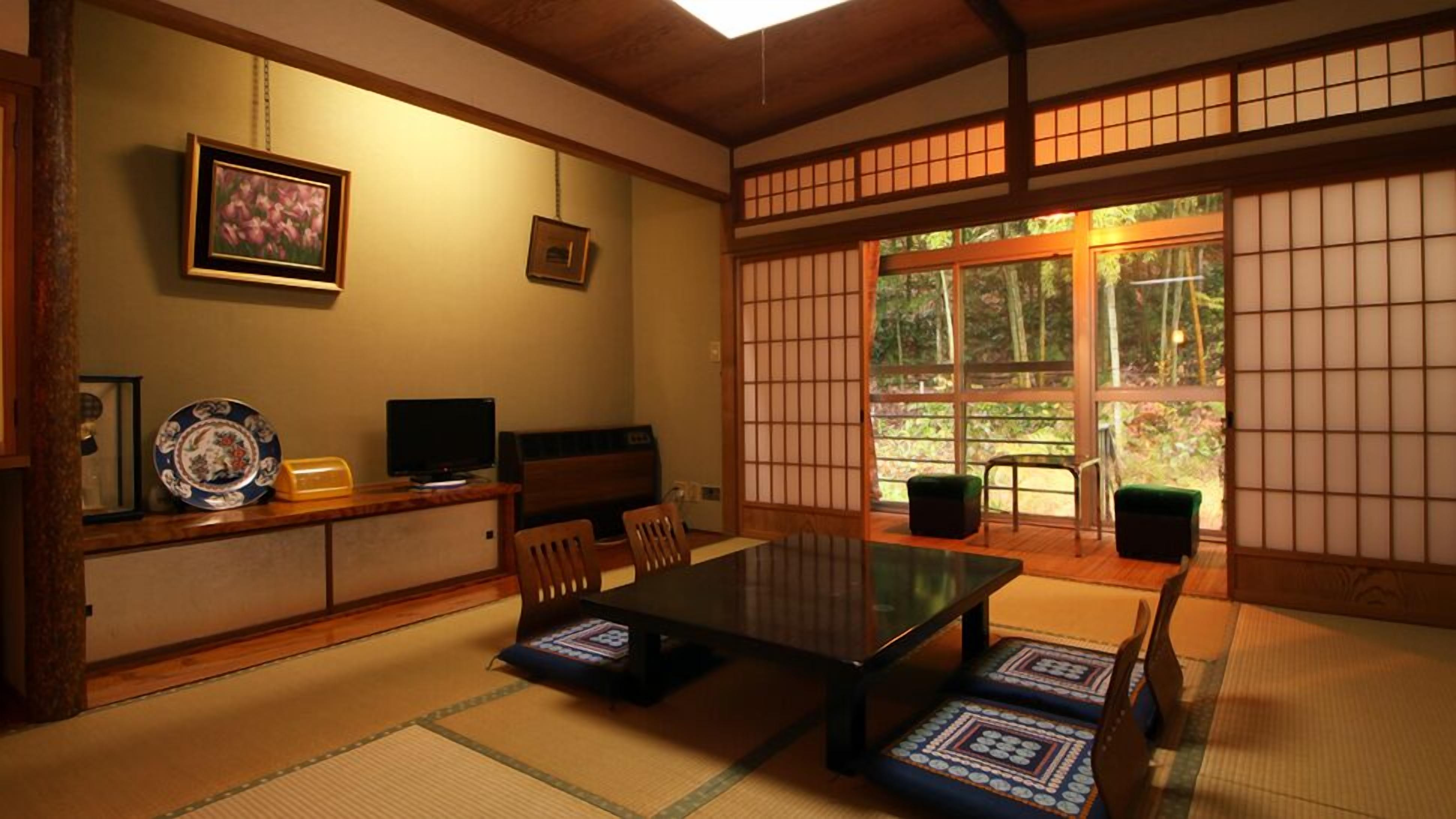 Une pièce de style japonais traditionnel, avec un sol recouvert de tatamis, une table basse et des portes coulissantes.