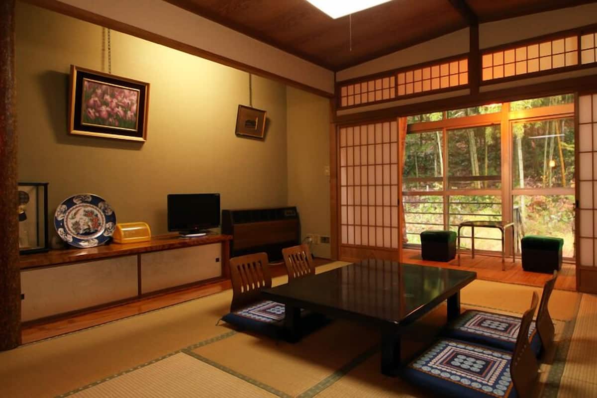 A traditional Japanese room with tatami flooring, a low table, and sliding doors.