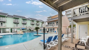 A pool area with lounge chairs and a small waterfall feature. - Beachfront Escape | Poolside Relaxation & Coastal Vibes (Corpus Christi)