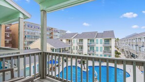 A hotel with multiple balconies overlooking a swimming pool.