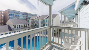 A balcony with a view of a swimming pool and adjacent buildings. - Beachfront Condo | Stunning Ocean & Pool Views, 3 Balconies (Corpus Christi)
