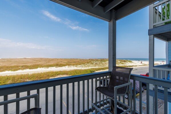 Un balcon avec vue sur la plage et l’océan.