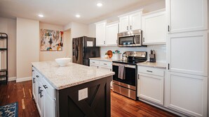 A modern kitchen with white cabinets, stainless steel appliances, and a granite countertop. - 6 bedroom Large house in Pickwick district Springfield Near MSU (Springfield)