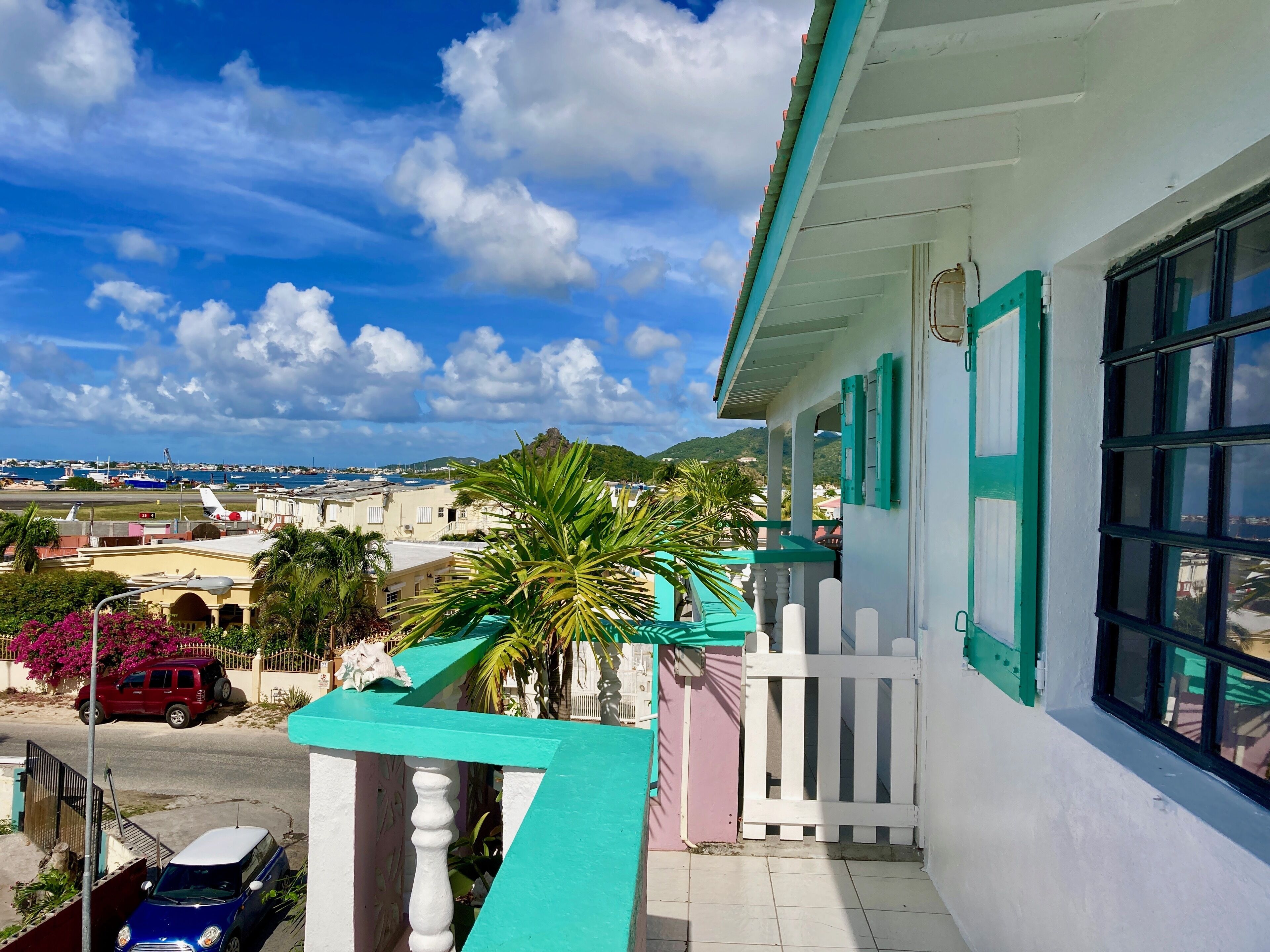 A balcony with a view of a marina and a hilly landscape.