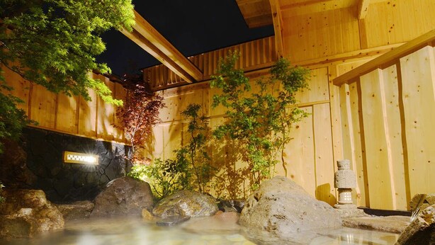 A hot spring area with stone tiles, wooden structures, and greenery. - Nihon Ryokan Utsuwa Beppu Kannawa (Beppu)