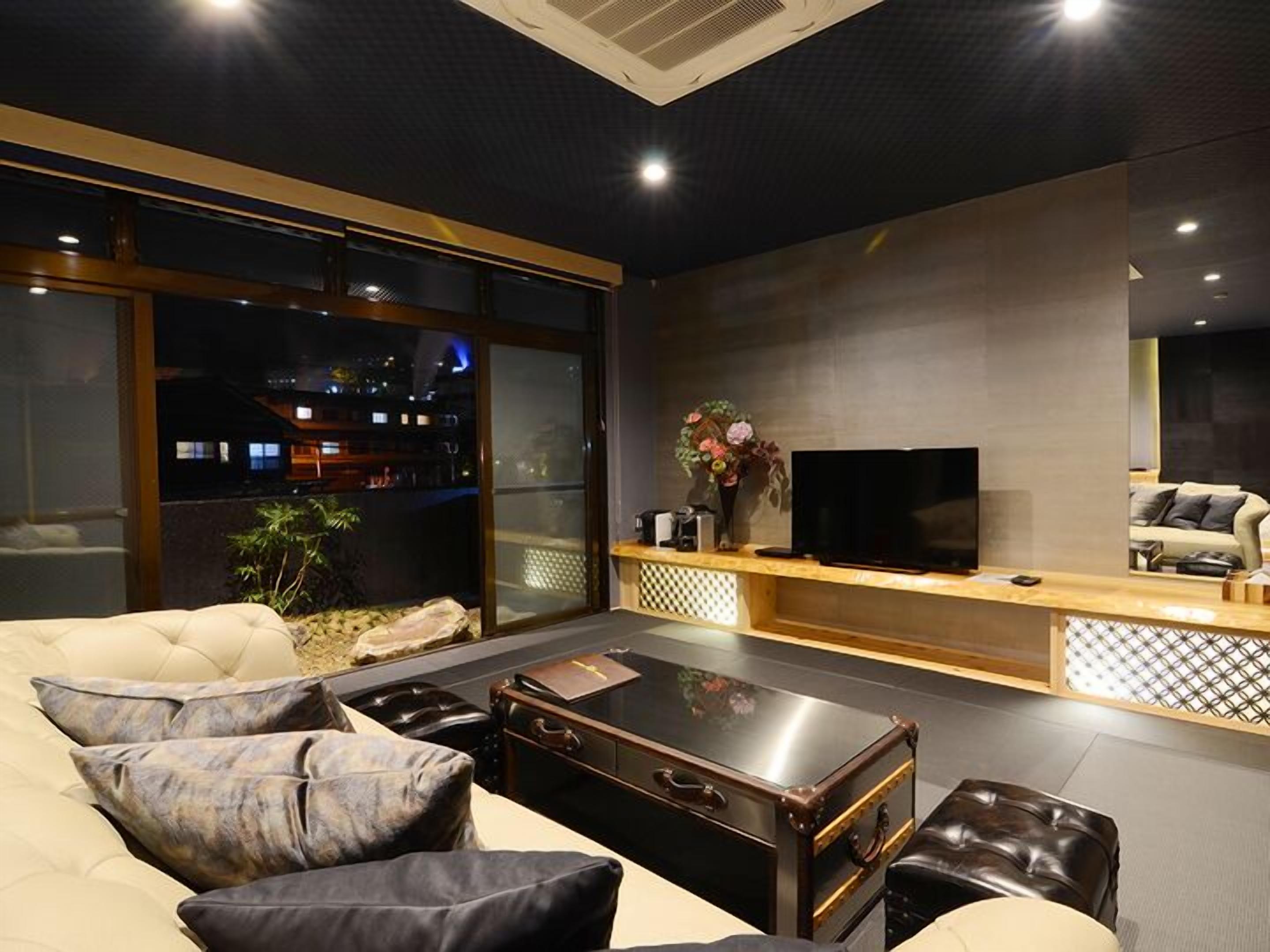 Un salon moderne comprenant un canapé, une table basse, un téléviseur et un vase décoratif.