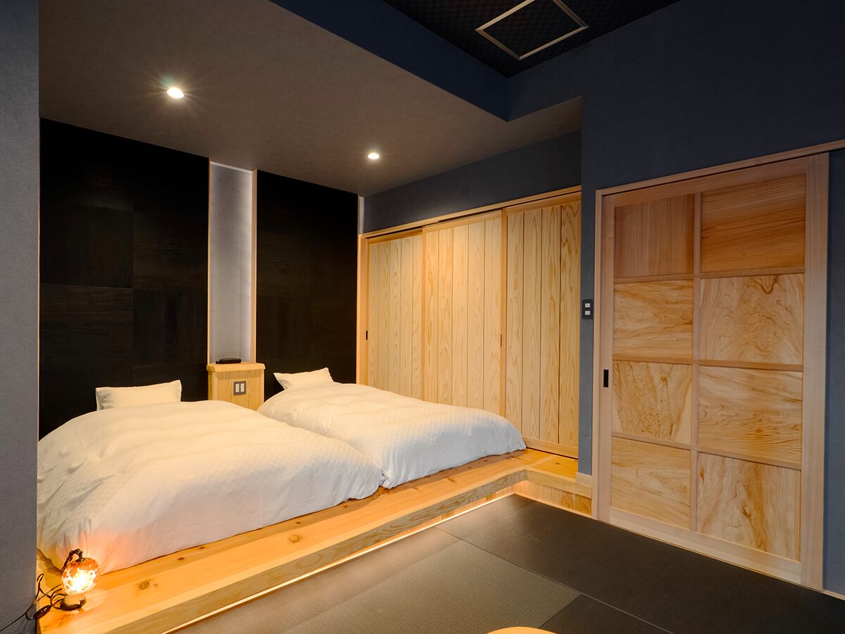 A modern bedroom with a large bed, wooden paneling, and a built-in wardrobe.