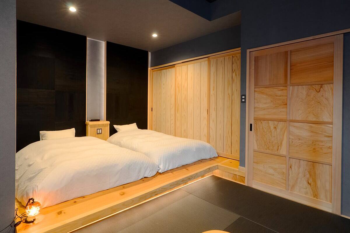 Ein modernes Schlafzimmer mit einem großen Bett, Holzvertäfelung und einem eingebauten Kleiderschrank.