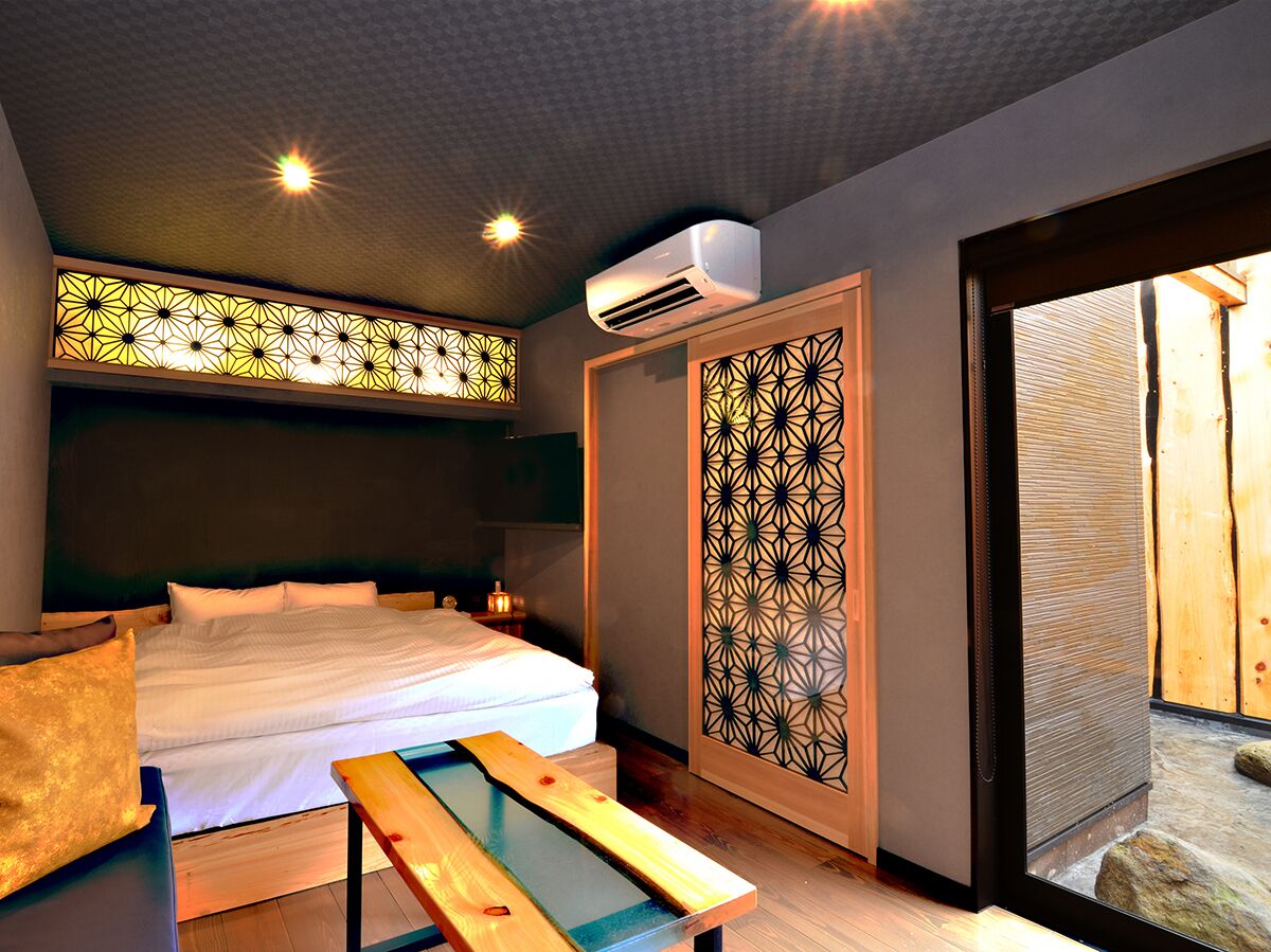A bedroom with a bed, bedside table, and a wooden bench.