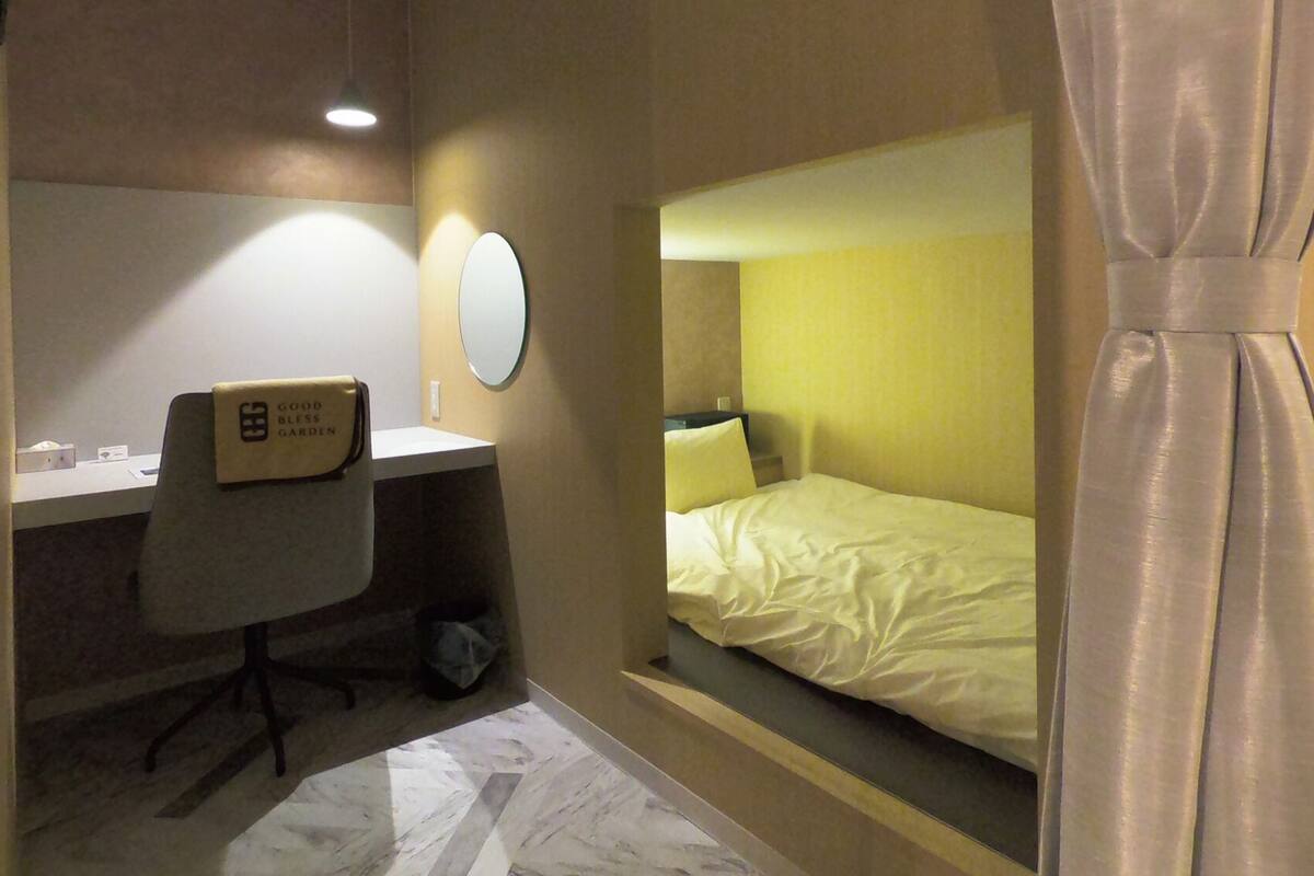 Une chambre d’hôtel équipée d’un bureau, d’une chaise et d’un lit.