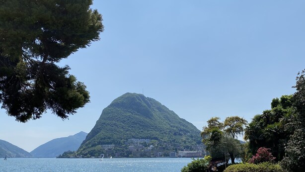 Un parque con un lago, una montaña y cielo despejado.