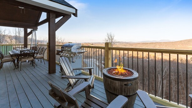 Una terraza con un brasero, mobiliario exterior y vistas del paisaje.