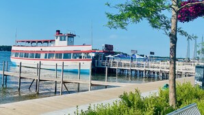 A white boat docked at a pier with a bar sign and a 'Queen' sign on the side. - Walking distance to historic Arnold’s Park and West Lake Okoboji (Arnolds Park)