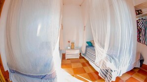 Un dormitorio con cama con dosel, mesita de noche y armario.