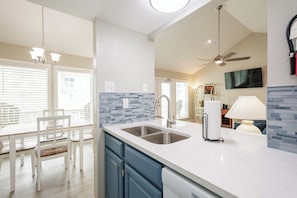 Enjoy cooking in this well-equipped kitchen with a large island, double sink, and dining area.