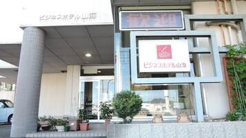 A building with a sign for 'SANKAI Business Hotel' and a digital display above the entrance.