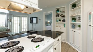 A modern kitchen with white cabinets, a black countertop, and a built-in stove. - Relaxing Gulf Coast Condo with Pool, Hot Tub & Balcony (Corpus Christi)