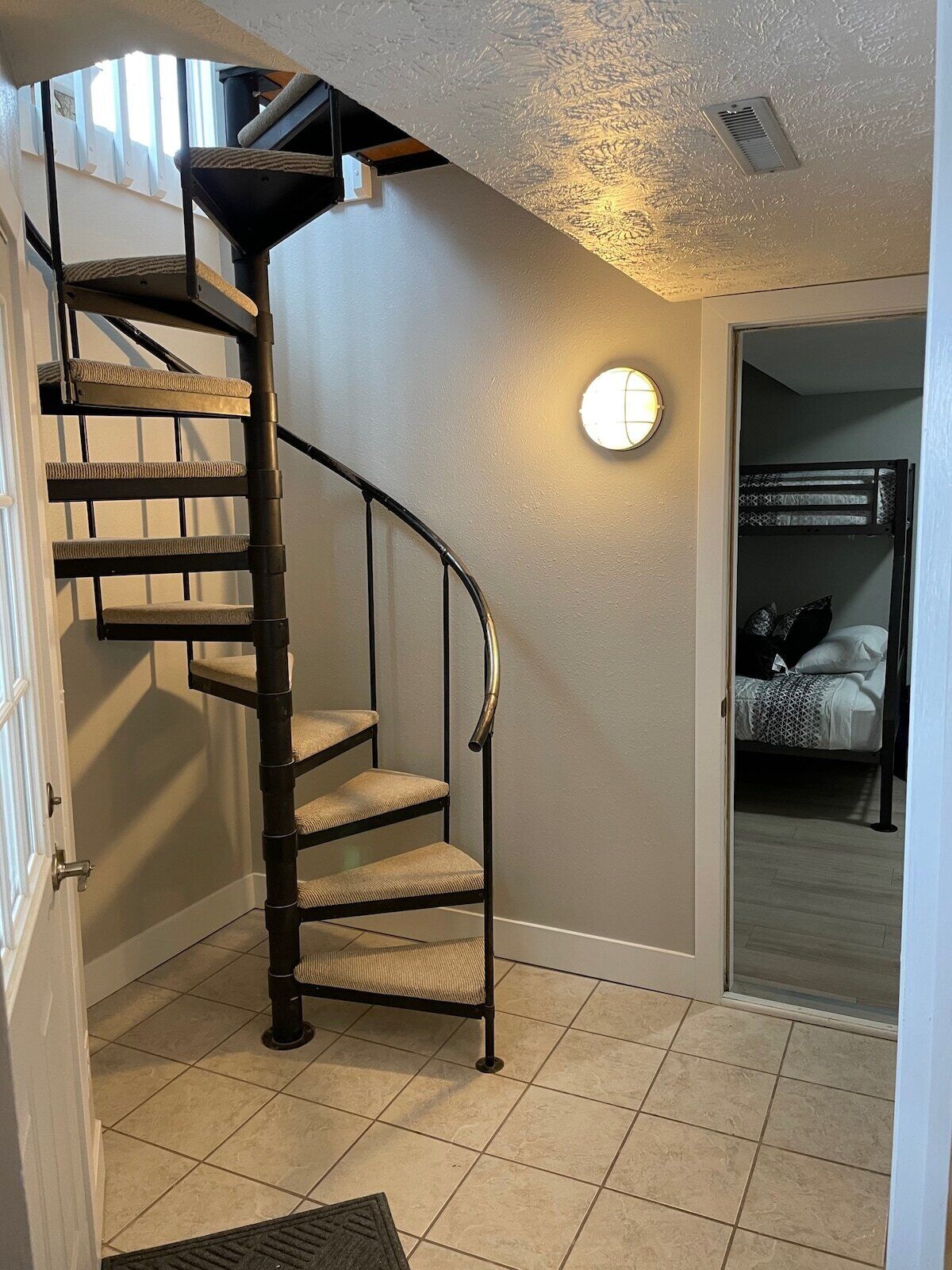 A spiral staircase with cushioned steps leading to a landing.