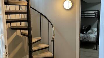 A spiral staircase with cushioned steps leading to a landing.