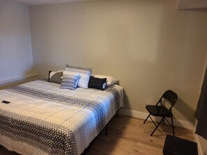 Une chambre à coucher avec un lit, une chaise et une petite table.