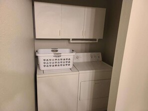 Un espacio pequeño para la lavandería, con lavadora y tendedero.