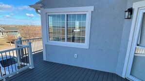 A deck with a railing, a window, and a chimney. - Bayview Condo #4, Ogallala Beach (Ogallala)