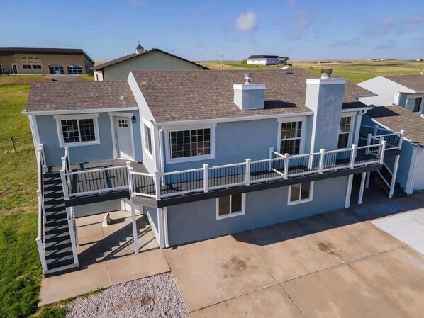 A two-story residential building with a covered outdoor area and a staircase leading to the upper level.