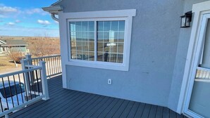 Une terrasse avec une balustrade, une fenêtre et une cheminée.