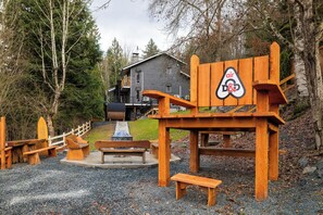 A wooden structure with a sign indicating an airfield, surrounded by benches and a playground area.